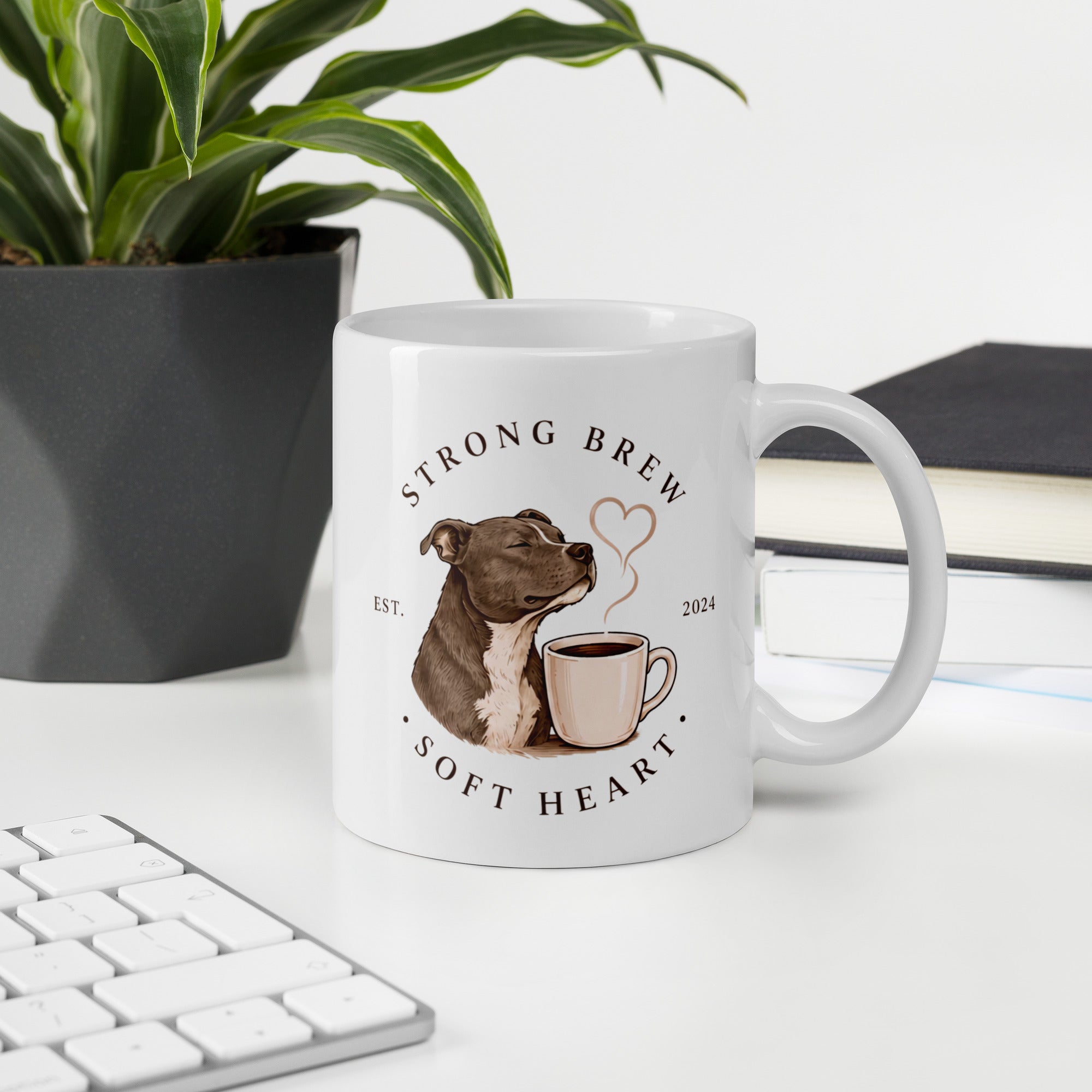 Coffee mug on office desk with the words strong brew soft heart and a picture of a Staffy