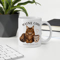 Coffee mug on desk with picture of Maine Coon